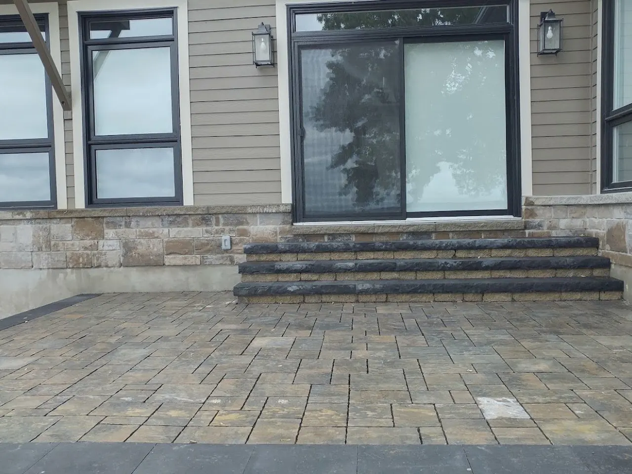 Stone-veneer house with paver patio in Almonte by ALM Construction